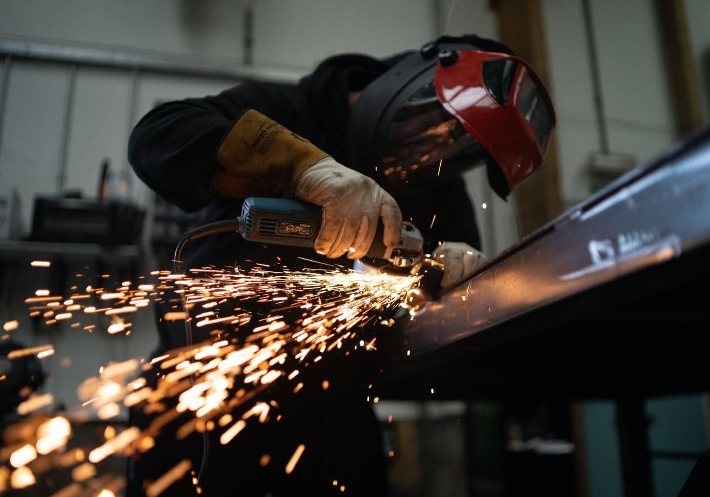 man using angle grinder on a piece of metal